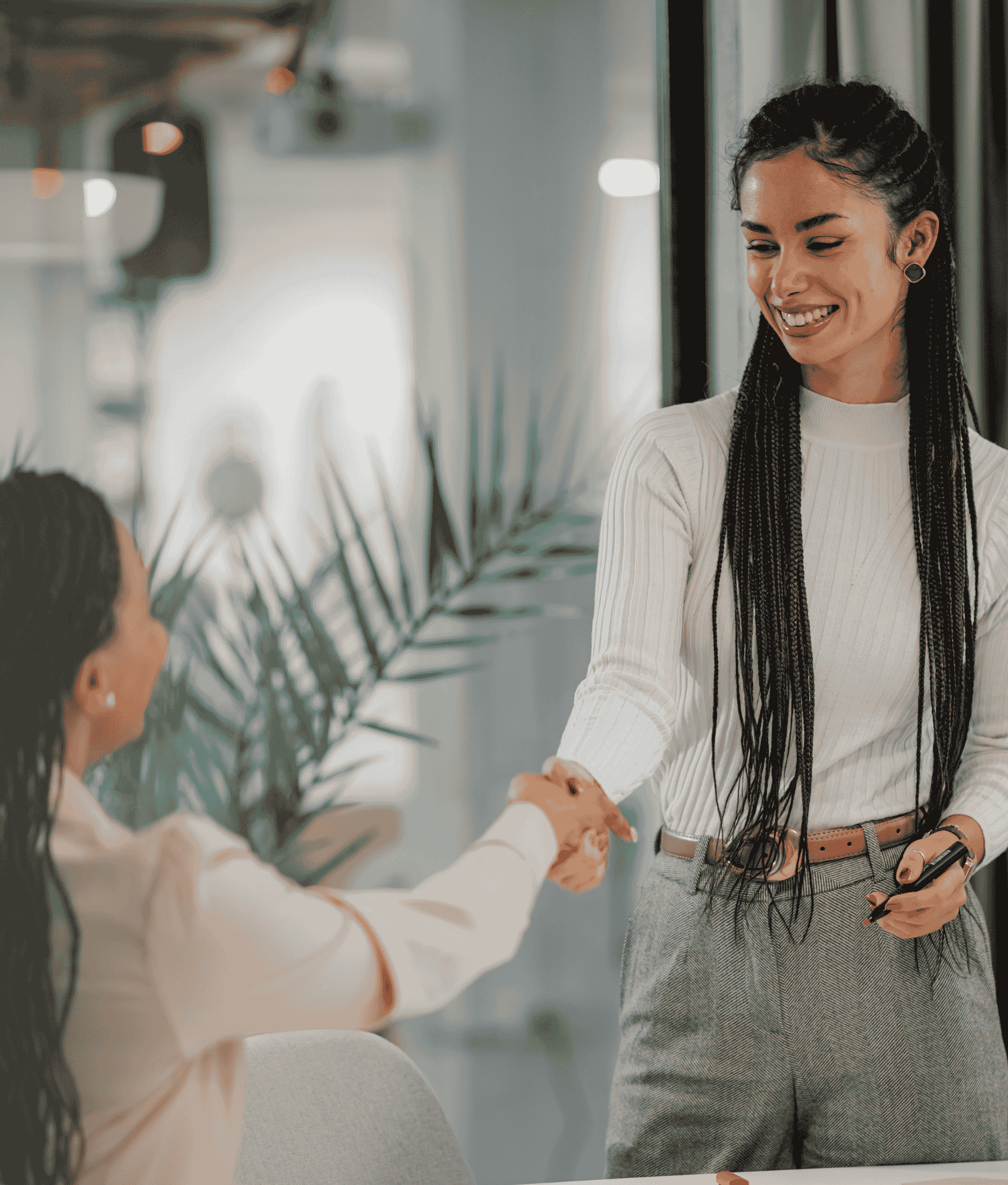 Young woman shaking hands with a new employee as part of her onboarding introductions