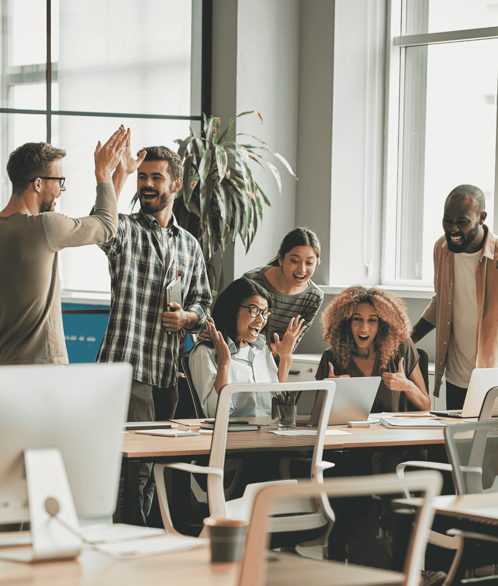 Team of young employees celebrating a win